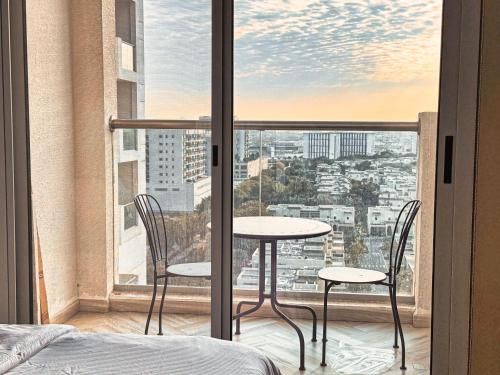 a table and two chairs in a room with a window at Warm and Elegant Studio in Dubai in Dubai