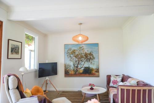a living room with a couch and a tv at Alluca Villa McLaren Vale Vineyard Escape in Blewitts Springs