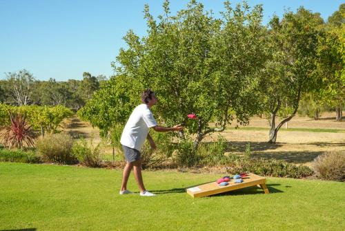 a woman throwing a frisbee at a picnic table at Alluca Villa McLaren Vale Vineyard Escape in Blewitts Springs
