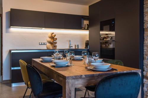 une table en bois avec des chaises et une salle à manger dans l'établissement ODYSSEE A201 Vaste appartement en vieux bois sur les pistes, vue panoramique, à La Toussuire