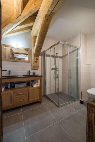 une salle de bain avec une douche en verre et un lavabo dans l'établissement ODYSSEE A201 Vaste appartement en vieux bois sur les pistes, vue panoramique, à La Toussuire