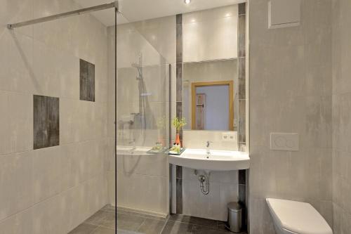 ein Bad mit einem Waschbecken und einer Glasdusche in der Unterkunft Be 550 in Wörgl