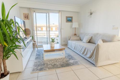 a living room with a couch and a coffee table at Proche Thalazur et plages, Parking privé, Piscine in Antibes