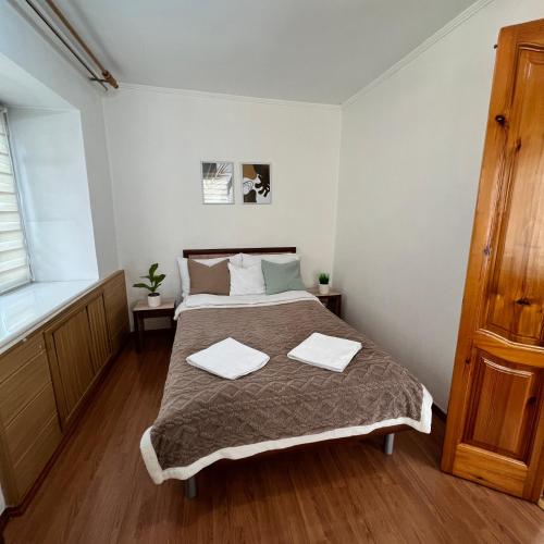 Un dormitorio con una cama con dos toallas encima. en Лободы 34 красиво и уютно, en Karagandá