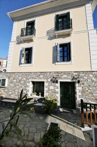 a building with two windows and a green door at Palladio Hotel - Portaria in Portaria