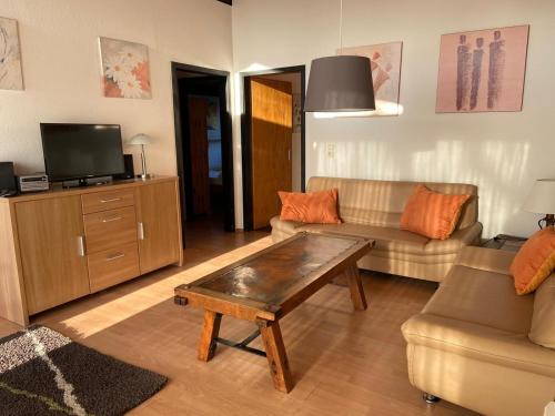 a living room with a couch and a tv at Ferienhäuser Fedderwardersiel Am Yachthafen 92 in Fedderwarderdeich