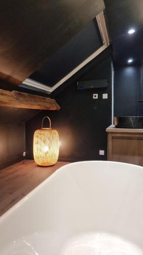 La salle de bains est pourvue d'une baignoire et d'un lavabo avec un sac. dans l'établissement Suite Osaka - Elégance et zénitude - 5 min plage, à Dunkerque