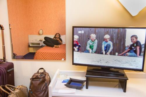 uma sala de estar com uma televisão e uma cama em Hotel Grassetti em Corridonia