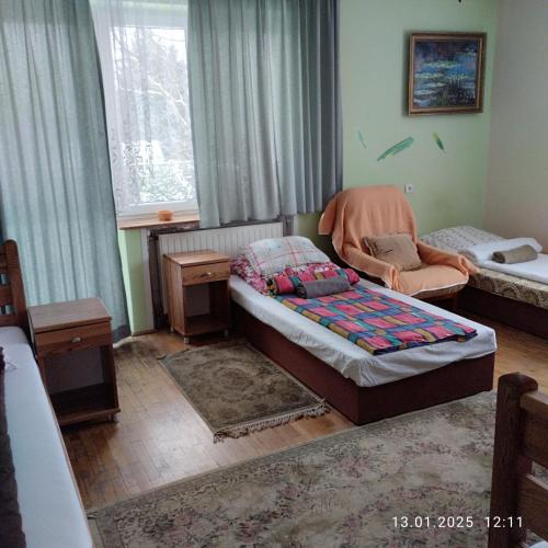 a bedroom with a bed and a chair and a window at Homestay Stróżówka in Gorlice