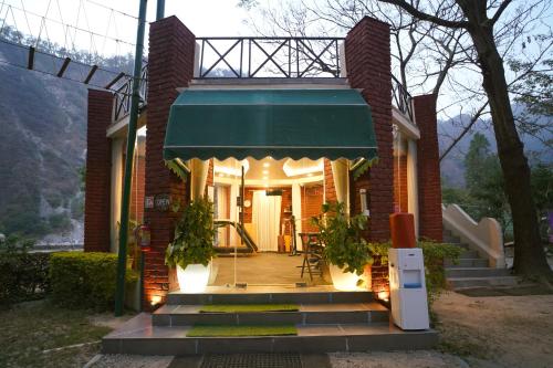 a brick house with a green awning and a porch at The Solluna Resort in Marchula