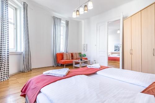 duża sypialnia z 2 łóżkami i krzesłem w obiekcie Simple Apartment near Wiener Stadthalle w Wiedniu