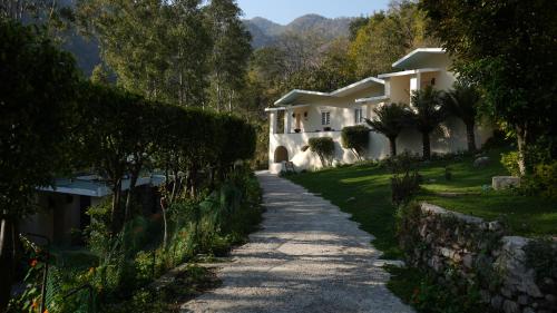 a house with a stone wall next to a road at The Solluna Resort in Marchula