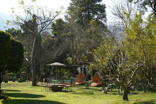 a park with tables and an umbrella and trees at The Solluna Resort in Marchula