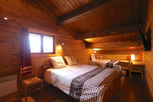 een slaapkamer met 2 bedden in een houten hut bij Chez Maguy Chambres d'hôtes in Les Angles