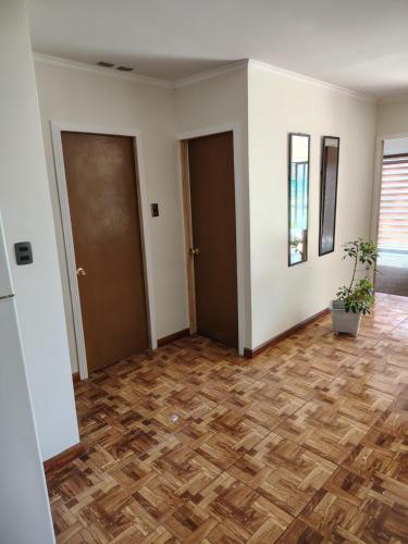 an empty room with two doors and a wooden floor at Cabañas mi refugio salto del laja in Salto del Laja