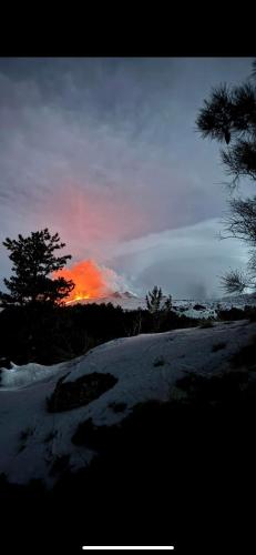 a sunset in the sky with snow and trees at Casetta sull’Etna in Nicolosi