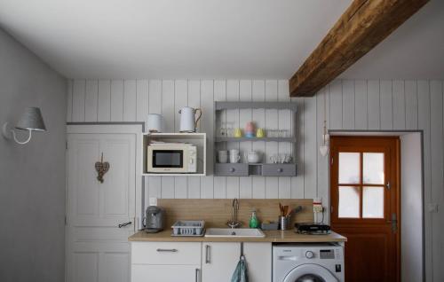 a kitchen with a sink and a microwave at La maison d'en face a cozy guesthouse in Saint-Euphrône