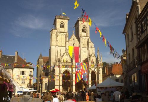 a group of people walking in front of a church at La maison d'en face a cozy guesthouse in Saint-Euphrône