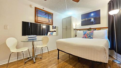 a bedroom with a bed and a table and chairs at Waikiki Grand Hotel Official Site in Honolulu
