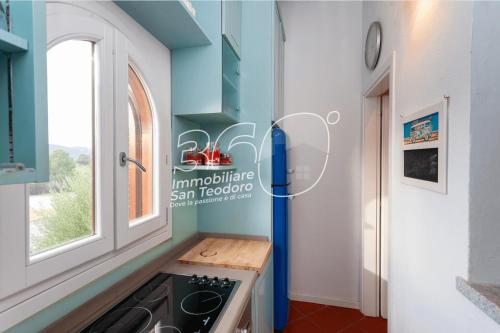 a kitchen with a refrigerator next to a window at Trilo Galathee g8 in Puntaldia