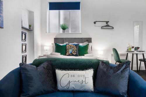 a blue couch in a living room with a bed at WhiskAwayStays Foregate Studio No 3 in Worcester