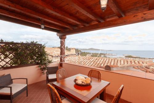a table and chairs on a balcony with a view of the ocean at Trilo Galathee g8 in Puntaldia