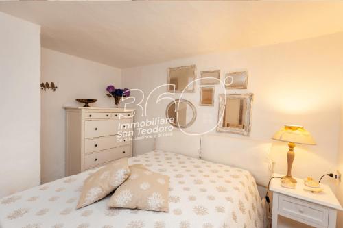 a bedroom with a bed and a desk with a lamp at Trilo Galathee g8 in Puntaldia