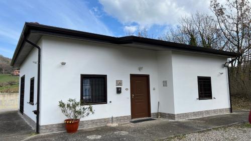 a small white building with a brown door at Lo Specchio di Alice in Lioni