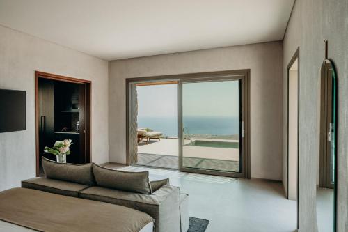 a living room with a couch and a view of the ocean at Santorini Sky, Luxury Resort in Pirgos