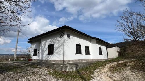 a white building with a black roof on a hill at Lo Specchio di Alice in Lioni