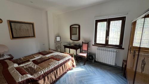 a bedroom with a bed and a desk and window at Lo Specchio di Alice in Lioni