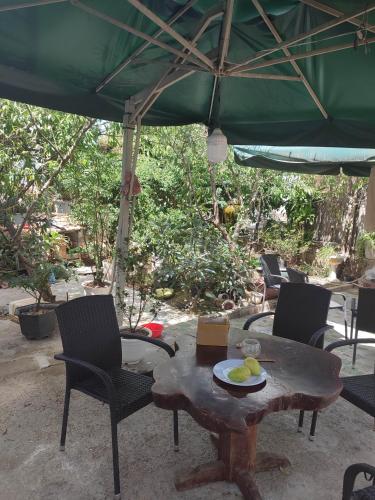 a table and chairs under a green umbrella at Tiên Hoa Sơn Villa in Da Lat
