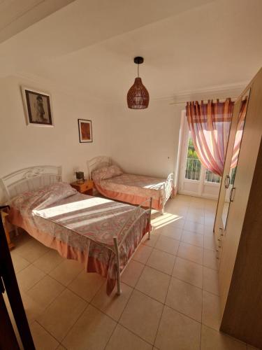 une chambre avec deux lits et une fenêtre dans l'établissement Appartement au premier étage dans maison de charme avec grand jardin au RDC, à Banyuls-sur-Mer