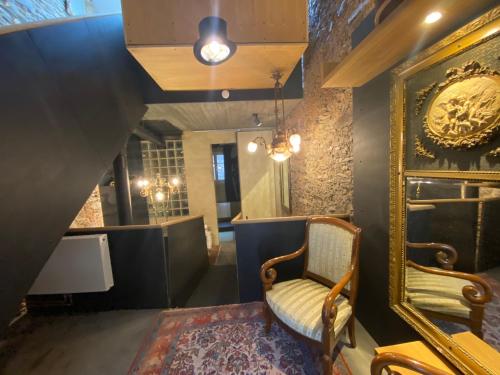a room with a chair and a mirror at Studio Beim Mulles 'Schapp' in Vianden
