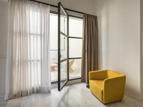 a yellow chair in a room with a window at Fetén in Valencia