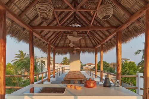a large wooden pavilion with a table on a beach at Casa Ohma La Punta in Brisas de Zicatela