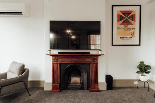 a living room with a fireplace and a chair at Charming 2-Bed Apartment in Launceston CBD in Launceston