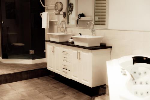 a bathroom with two sinks and a bath tub at Charming 2-Bed Apartment in Launceston CBD in Launceston
