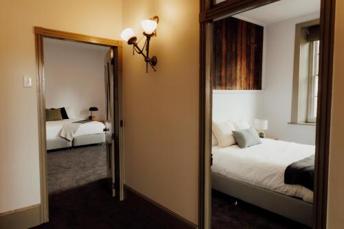 a bedroom with two beds and a mirror at Charming 2-Bed Apartment in Launceston CBD in Launceston