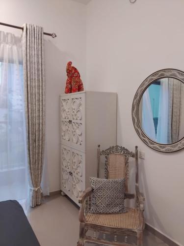 a mirror and a chair in a room at The Golf Heaven in Gonapola