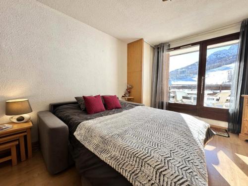 una camera da letto con un letto e una grande finestra di Résidence L'alpage - APPARTEMENT PIED DES PISTES MAE-4591 a Vars