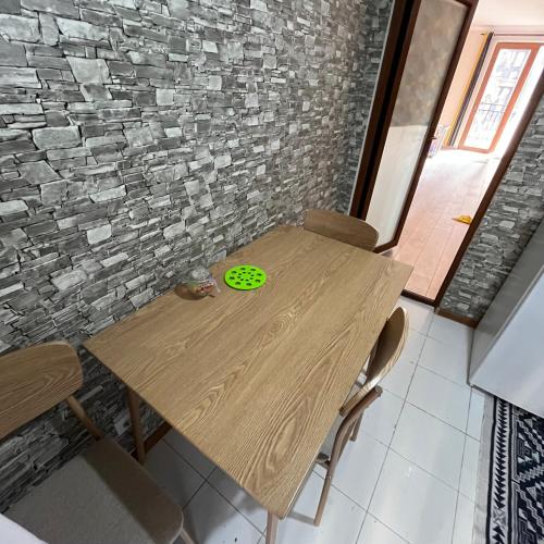 a wooden table with a green frisbee on it at Mika's Apartment in Tbilisi City
