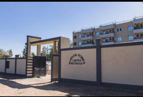 a building with a sign in front of a building at Charme Nest in Nanyuki