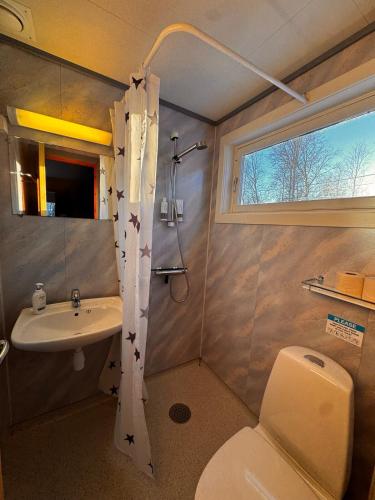 a bathroom with a toilet and a sink and a window at Ustedalen Lodge in Geilo