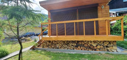 a wooden house with a pile of fire wood at Štiavnička in Mýto pod Ďumbierom