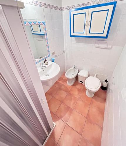 a bathroom with a toilet and a sink at Casa Lucca 3 in San Teodoro
