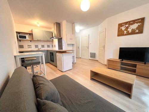 un salon avec un canapé et une cuisine dans l'établissement Appartement Cosy à Belfort, à Belfort