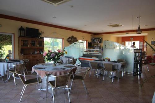 a restaurant with tables and chairs in a room at Villa Oasis, Piscina, Jacuzzi, Ténis e Praias! in Portimão