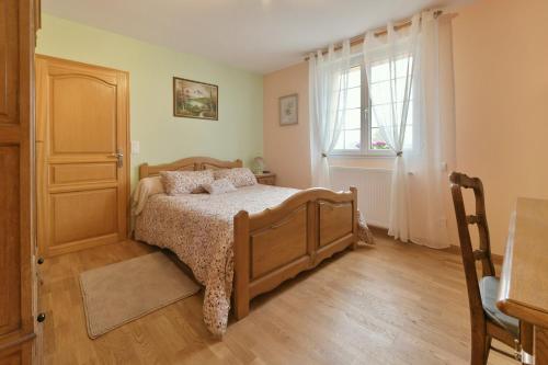 a bedroom with a bed and a window at Gîte du Pont d'Amourette in Mayenne