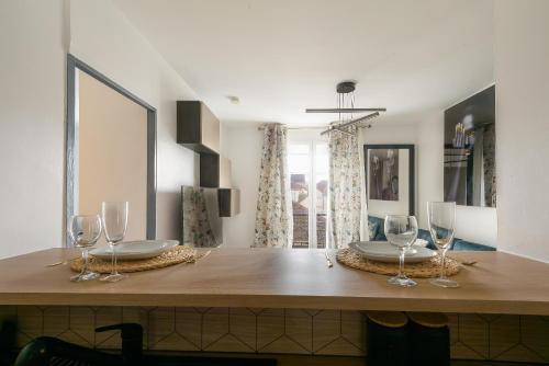 une table de salle à manger avec des verres à vin dessus dans l'établissement Aux Berges de Bailly - A 10min de Disneyland, à Bailly-Romainvilliers